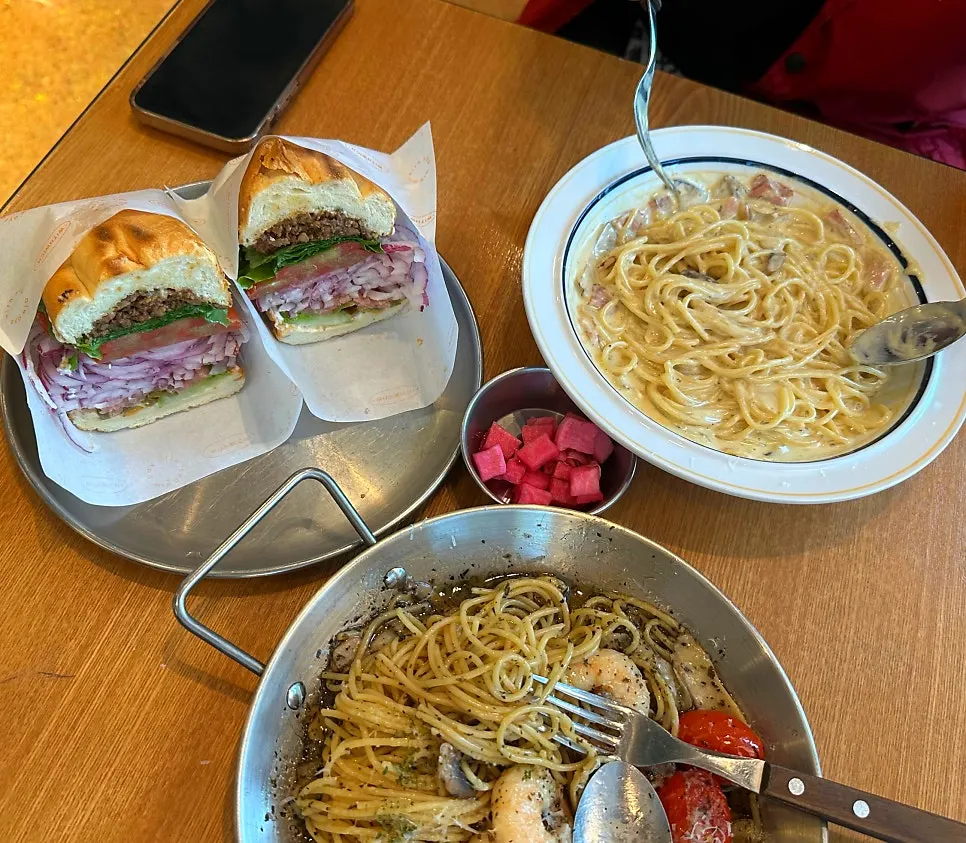 Table spread with sandwich and pasta together