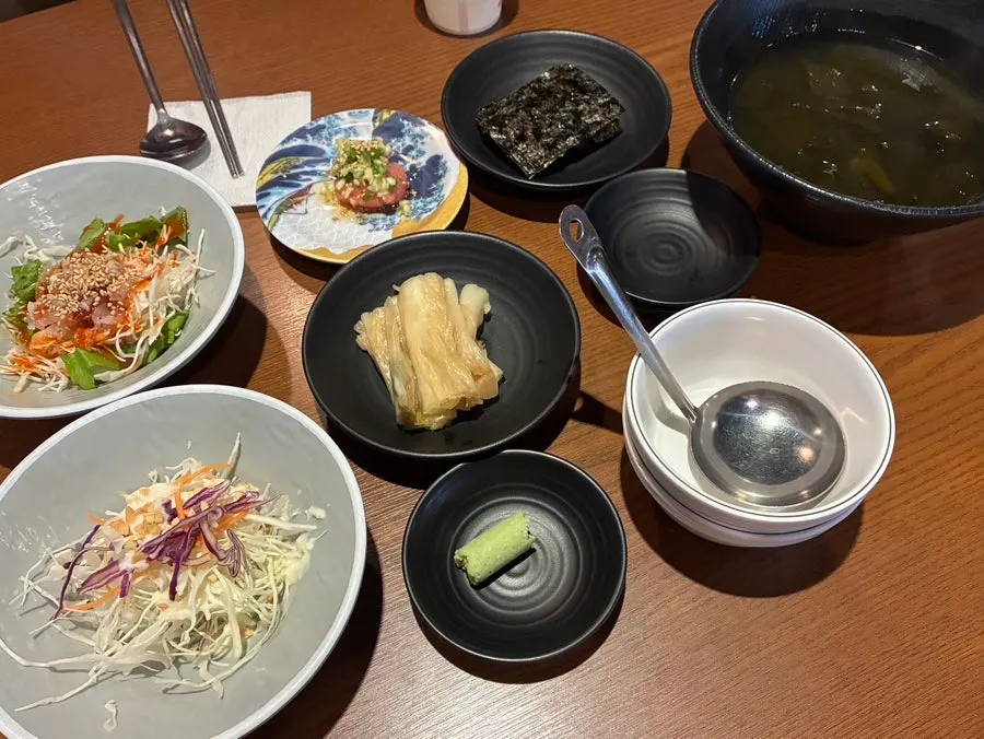 Basic side dishes including seaweed soup, aged kimchi, and sashimi salad