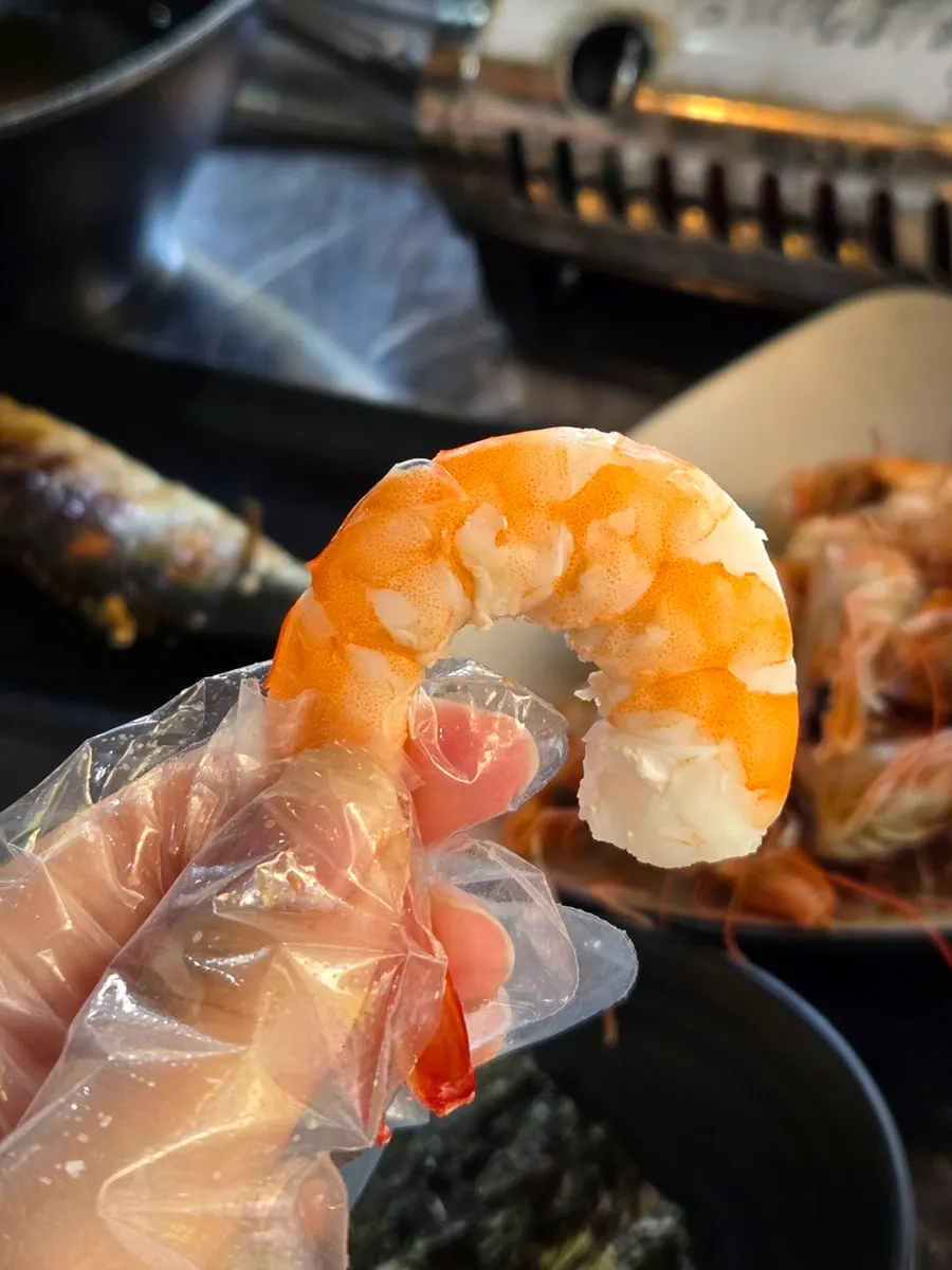 Close-up of salt-grilled shrimp held in hand