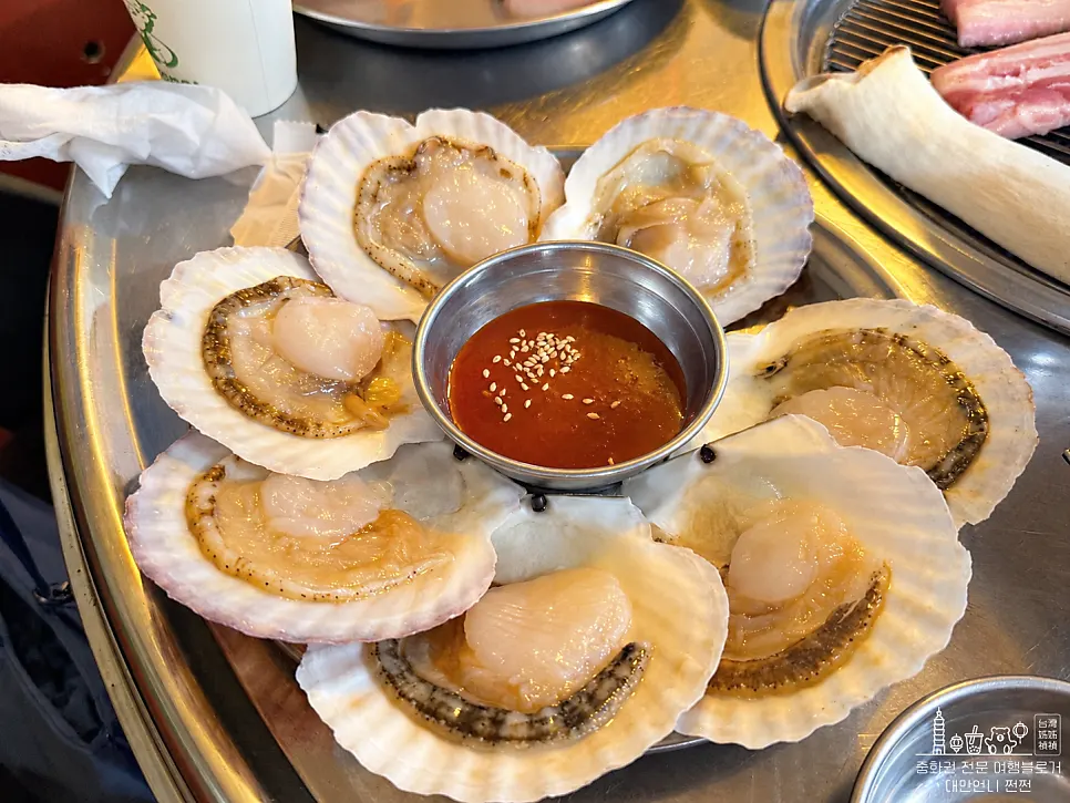 Daging dan kerang di atas arang sedang dipanggang dengan penyepit