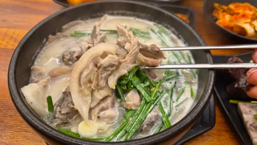 Rich sundaeguk broth filling a stone pot