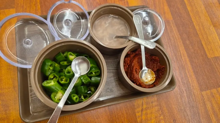 Broth-soaked chapsundae lifted on a spoon