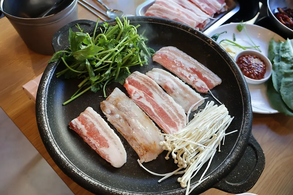 팬에서 익어가는 냉삼겹살과 미나리