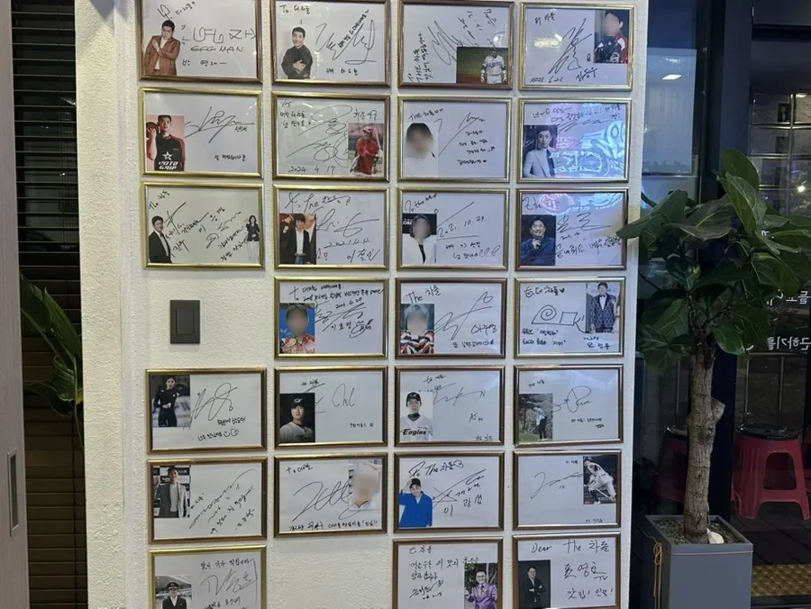 유명인 사인이 붙어 있는 매장 벽면