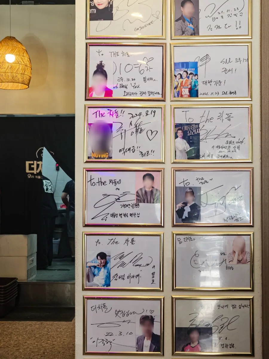 벽면에 걸린 연예인 방문 사진들