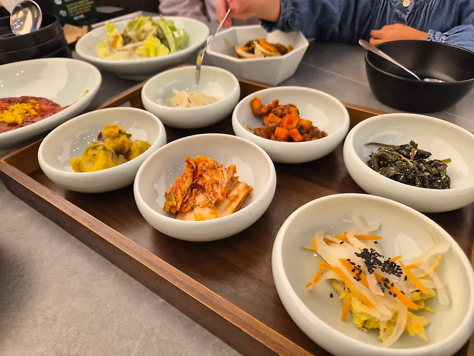 Set meal spread with grilled flounder, japchae, mung bean jelly, and more side dishes