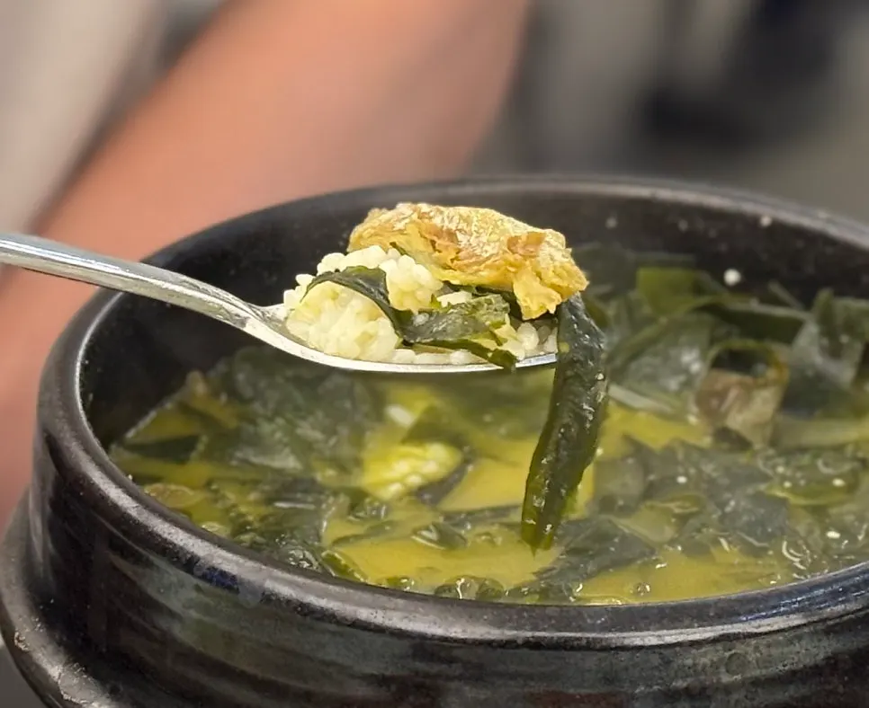 A spoonful of rice mixed into dried pollack seaweed soup broth