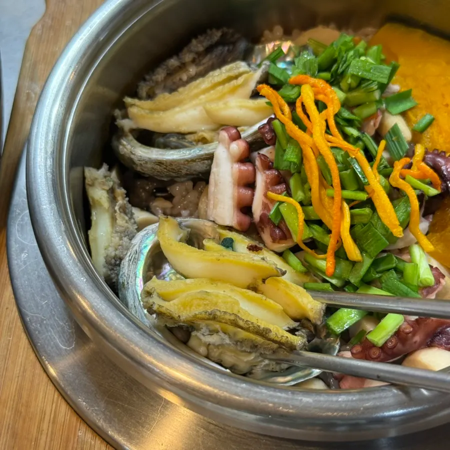 Cauldron rice topped with two whole abalones and octopus