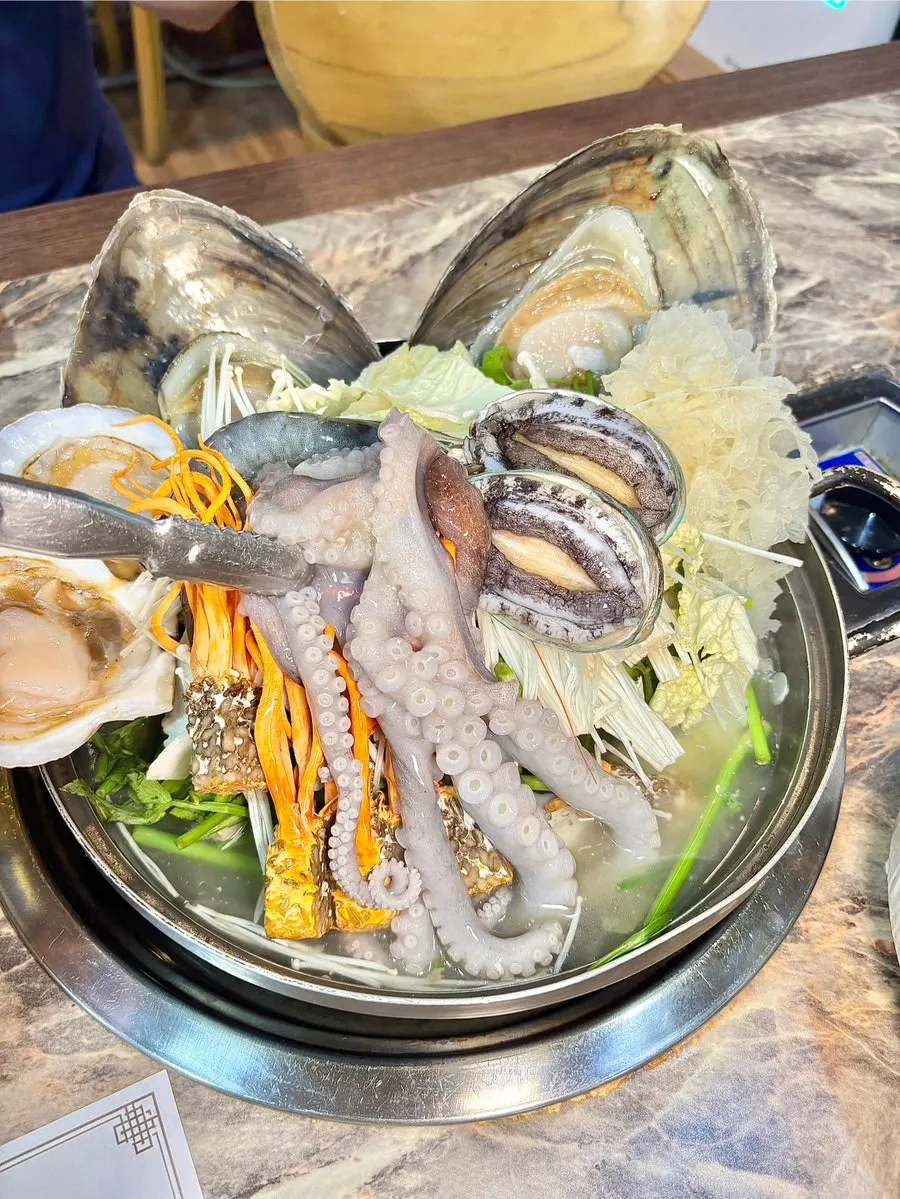 Visual of the haesintang topped with octopus and abalone