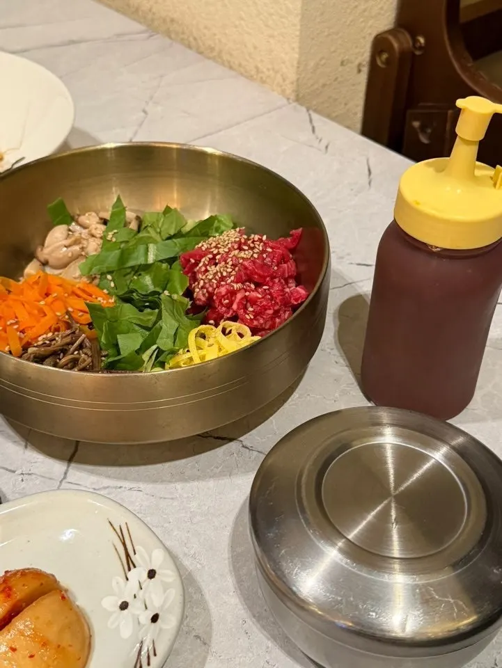 A full spread of yukhoe bibimbap and doenjang stew