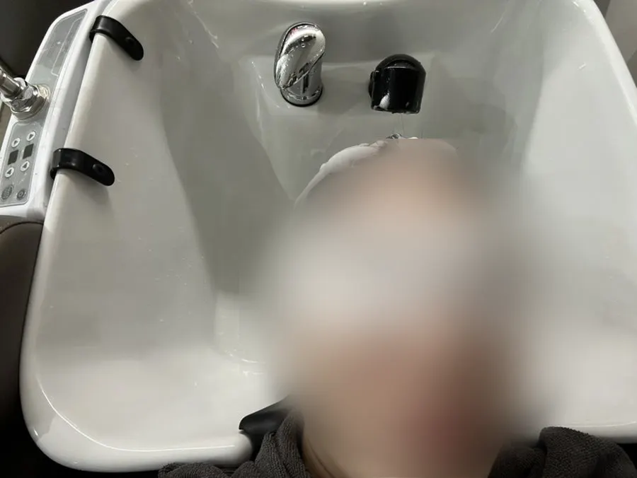 Getting a shampoo with an eye mask on