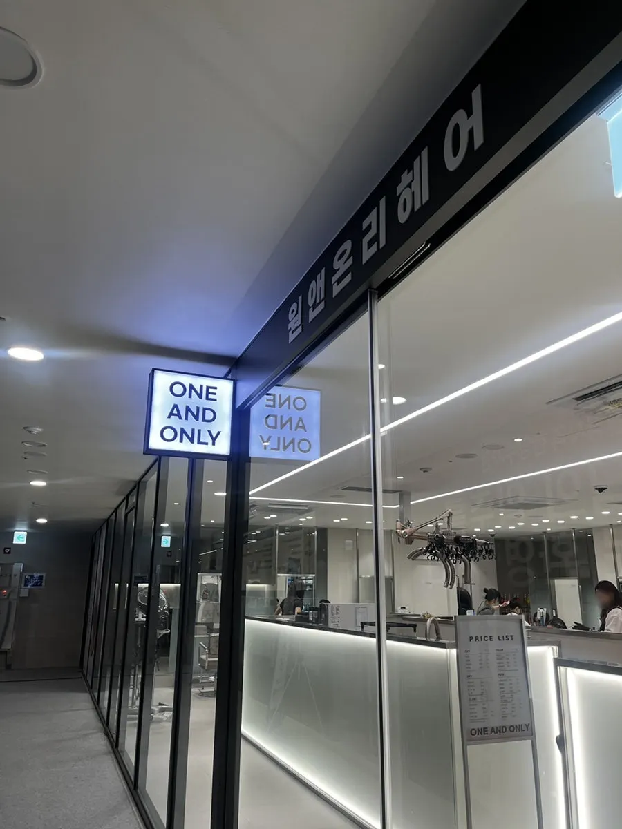 Glass entrance of One & Only Hair Gwacheon Government Complex Station, showing the interior