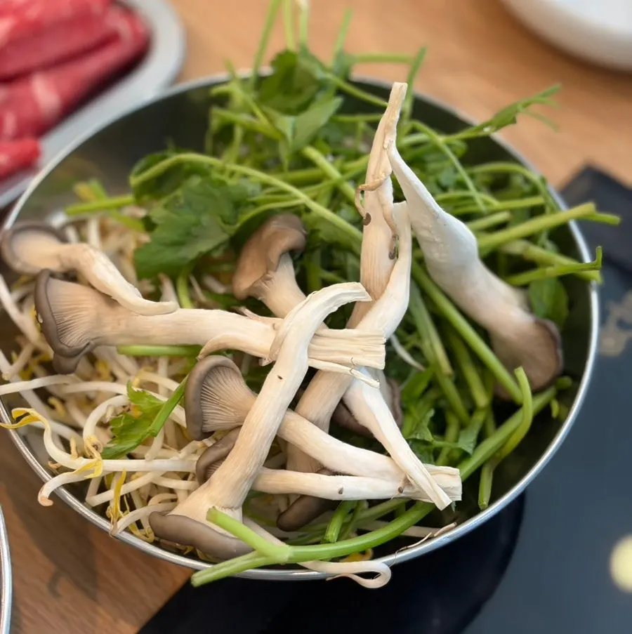 Second refilled pot with mushrooms, vegetables, and broth
