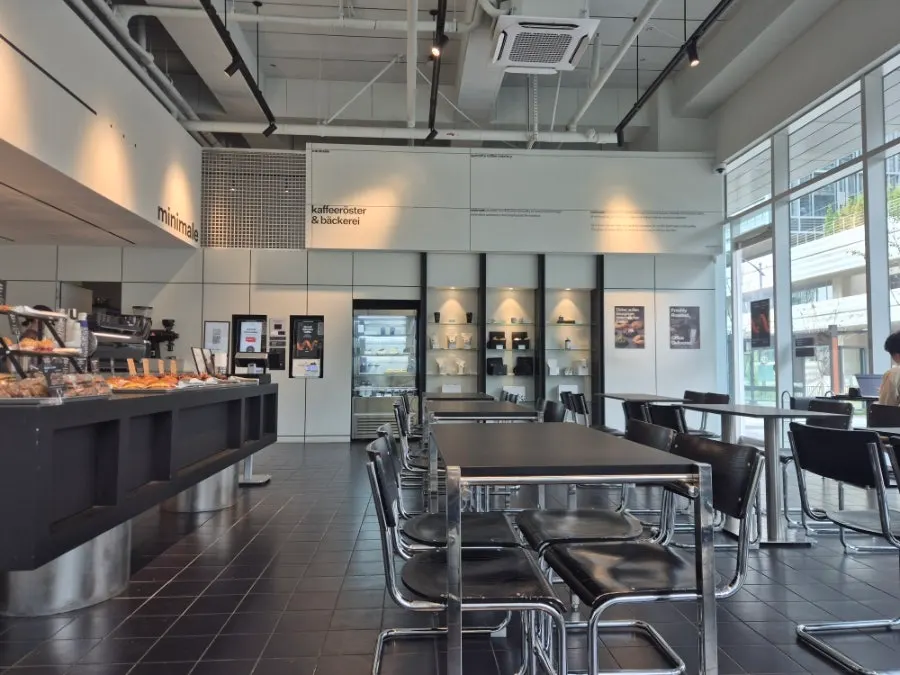 High-ceilinged café interior with black tables