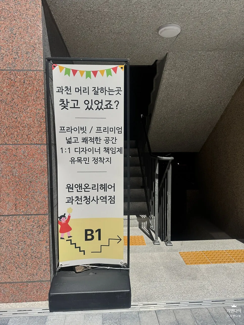 계단 앞에 세워진 원앤온리헤어 배너