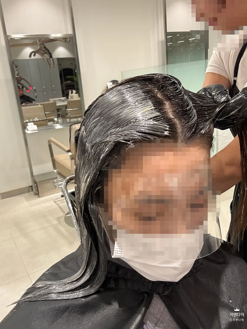 민트색 염색약을 모발에 도포하는 모습