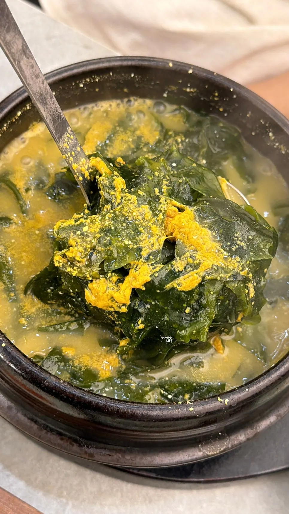 A spoonful of the sea urchin roe seaweed soup