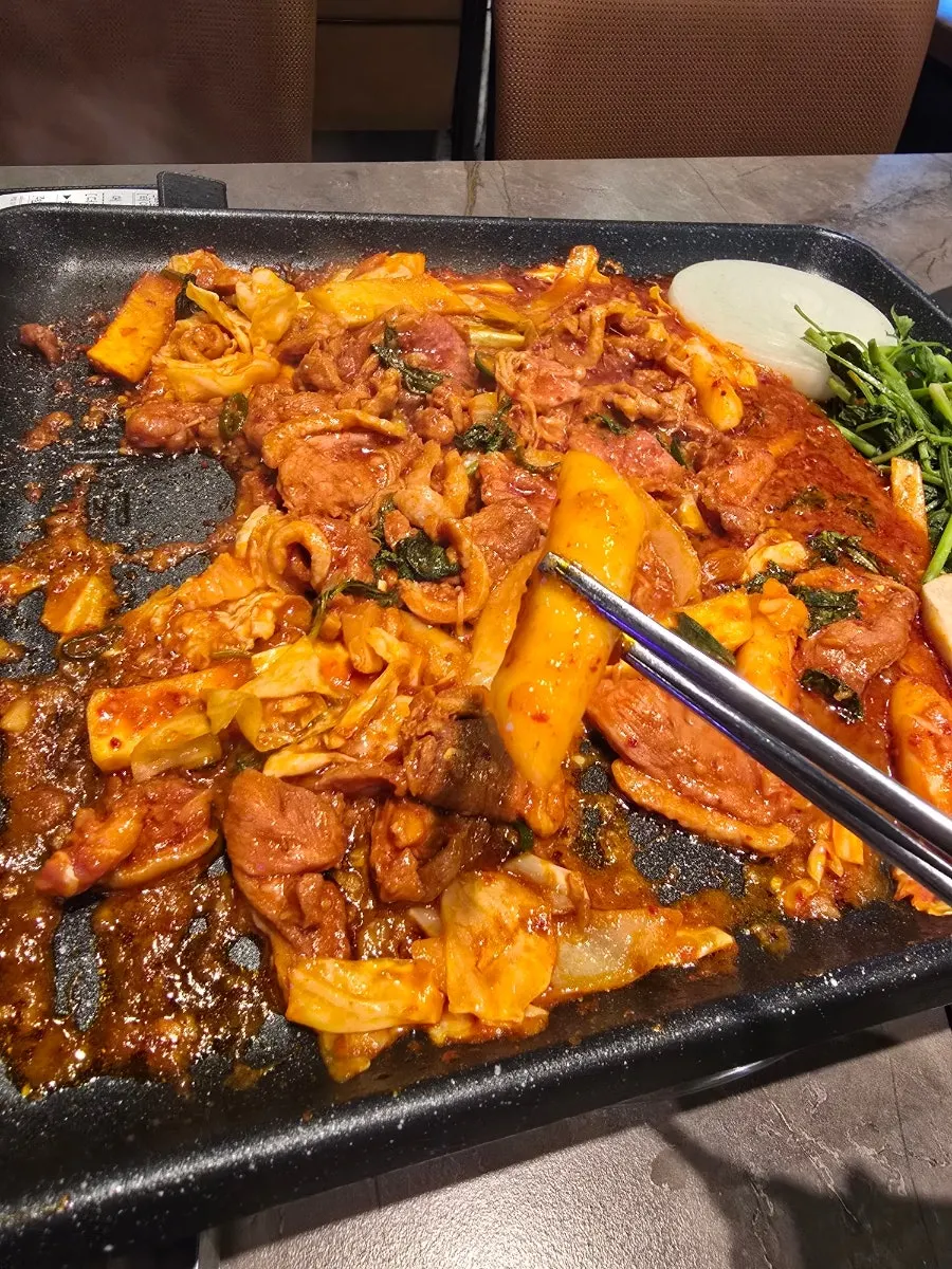 Duck jumuljeok and cabbage sizzling on the grill