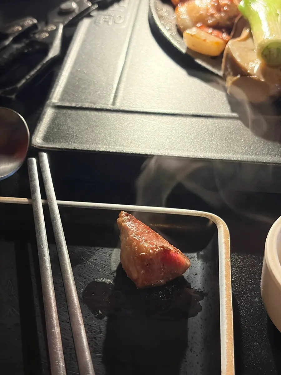 A piece of grilled meat dipped in anchovy salt
