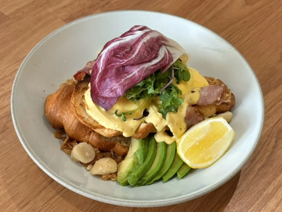 The Famous Benny with poached egg and avocado on croissant
