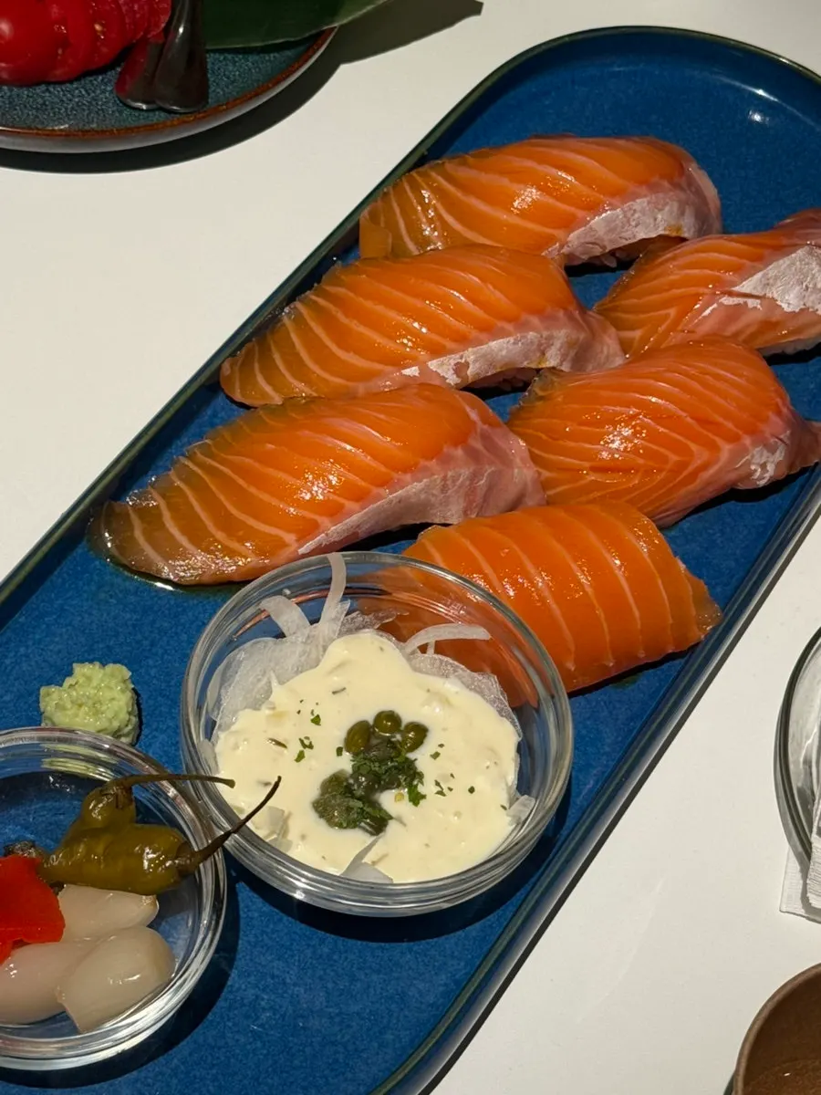Giant raw salmon sushi compared to a spoon