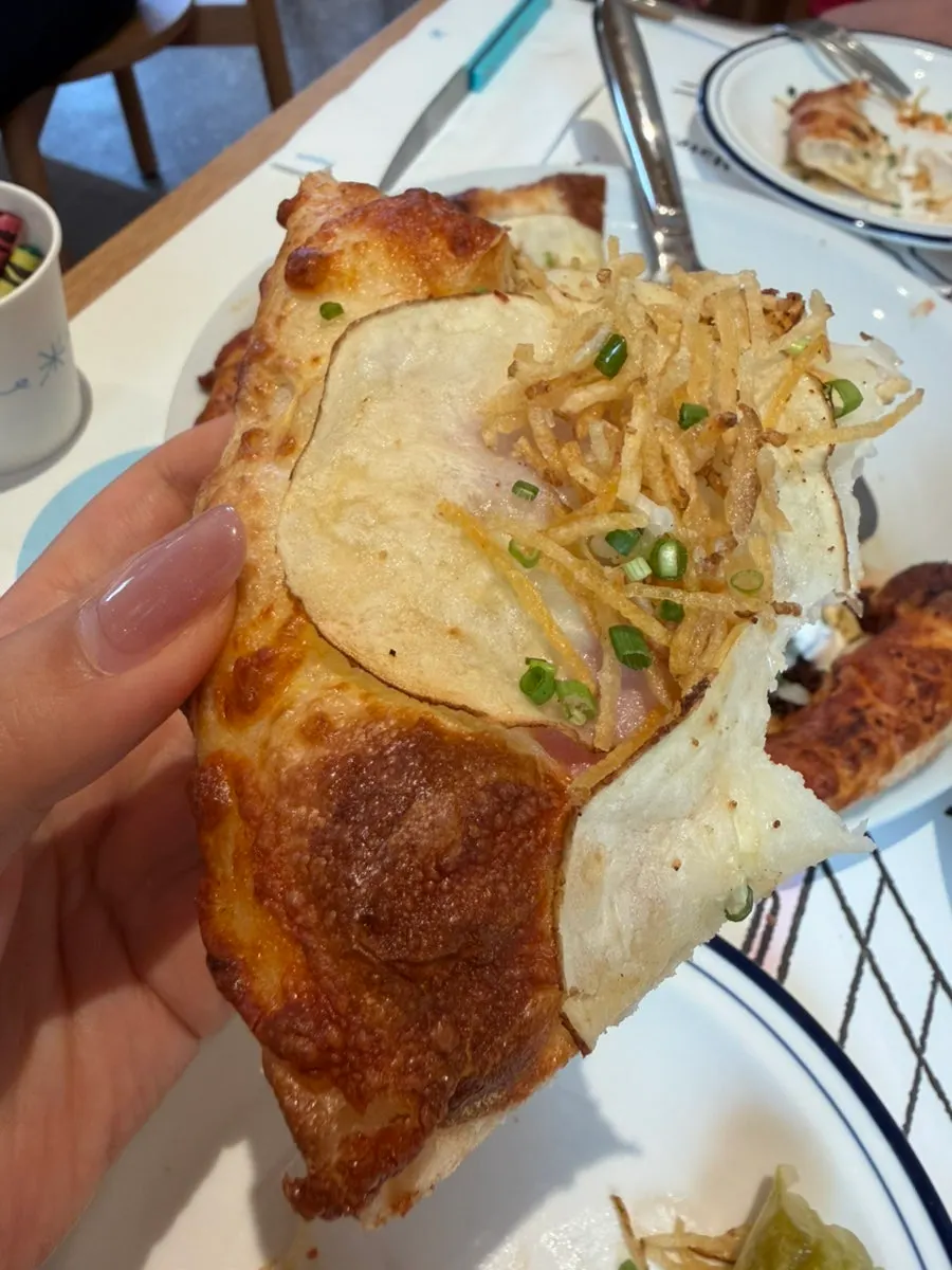 Birria pizza topped with cilantro and sour cream