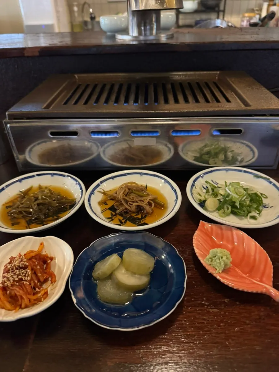Side dish spread with wasabi, green onion, and an egg yolk