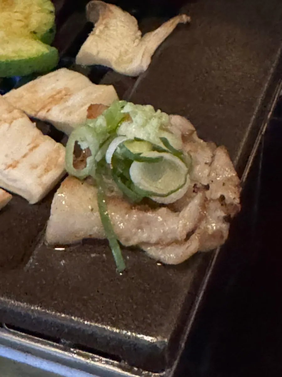 Pork belly topped with green onion and wasabi