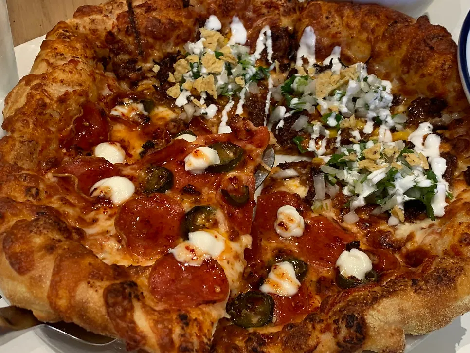 A slice of honey-drizzled hot honey pepperoni pizza