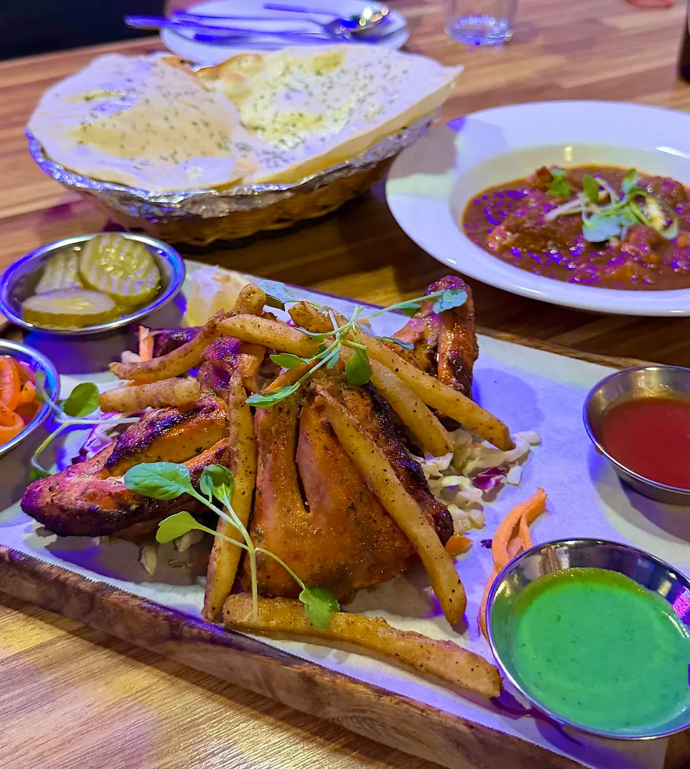 Scooping chicken curry with naan