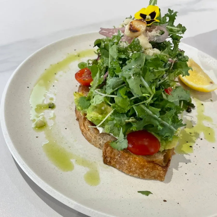 A plate of avocado toast piled high with avocado