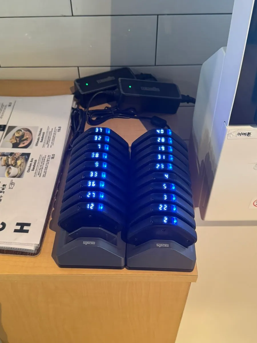 입구 키오스크와 옆에 놓인 종이 메뉴판