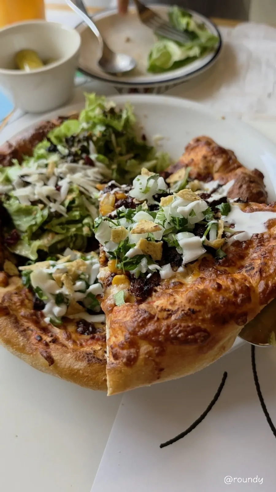 Pizza topped with birria meat and sour cream
