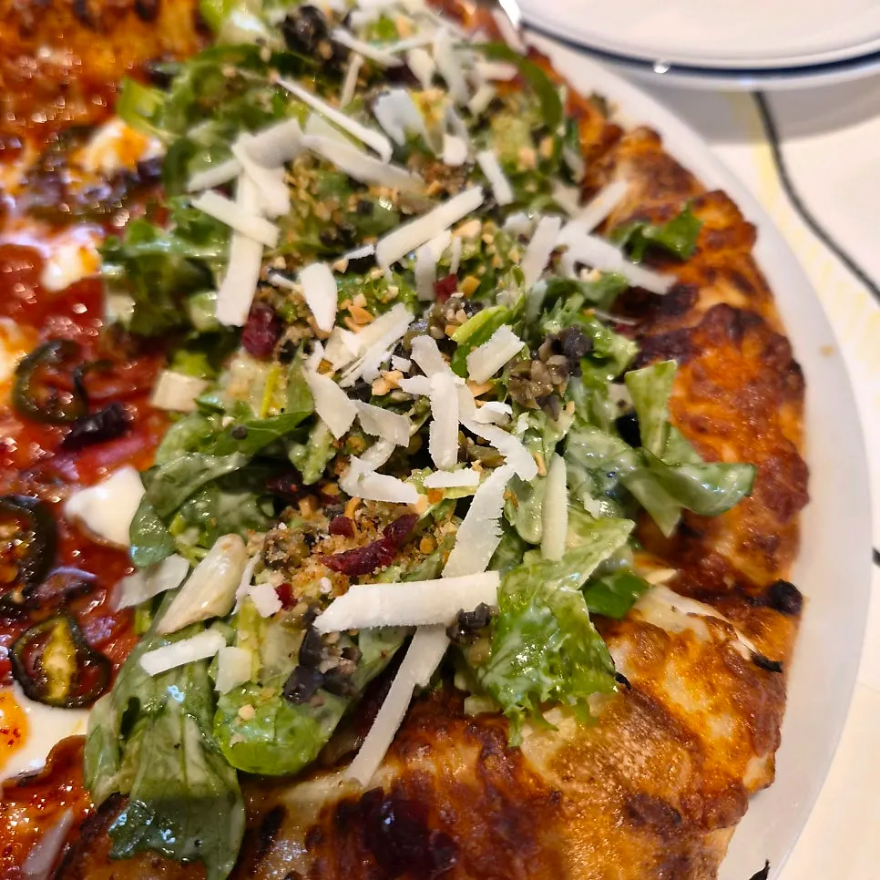 A slice of salad pizza topped with vegetables