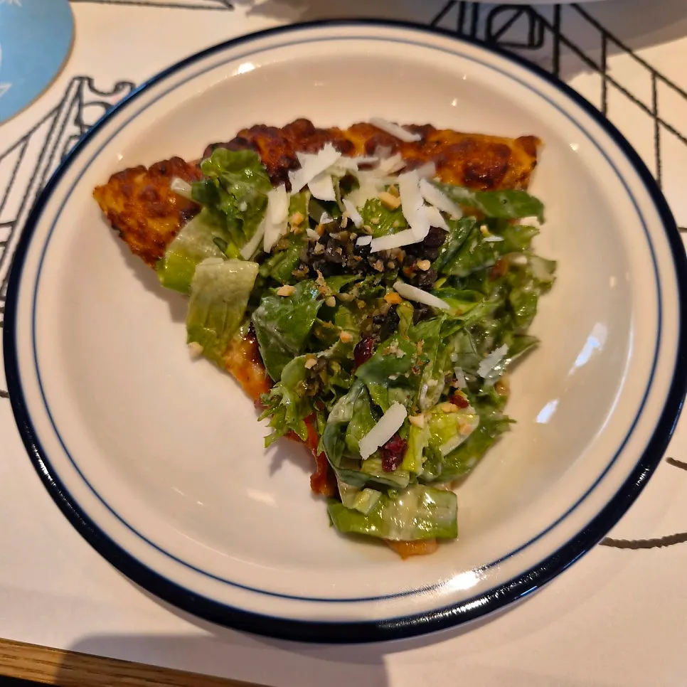 Salad pizza showing cranberries and nuts