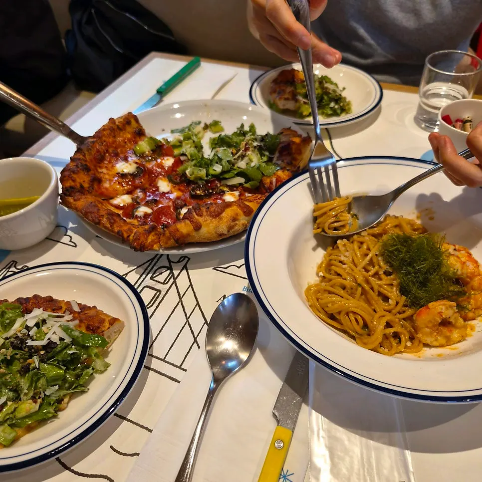Table set with the half-and-half pizza and bisque cream pasta together