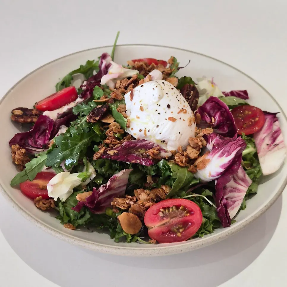 House salad topped with poached egg and cherry tomatoes