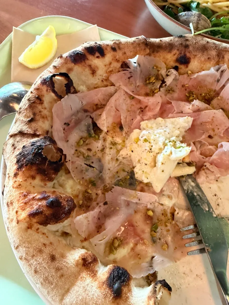 A slice of jambon pizza with chewy dough