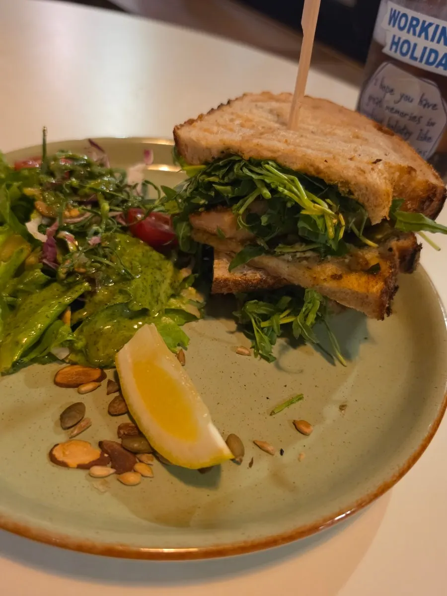 ピザのふちとサラダを一緒に巻いて食べる様子