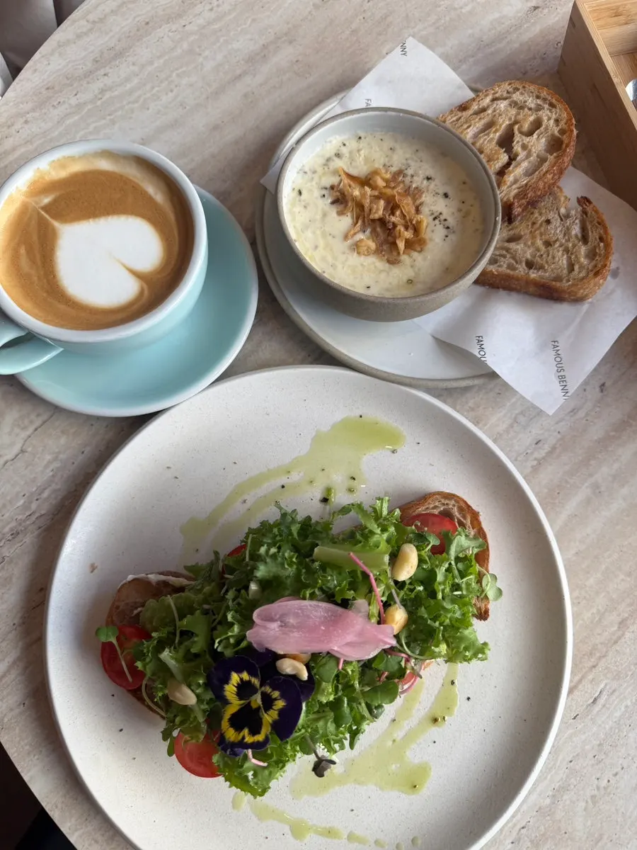 Open sandwich, soup, and latte on the table