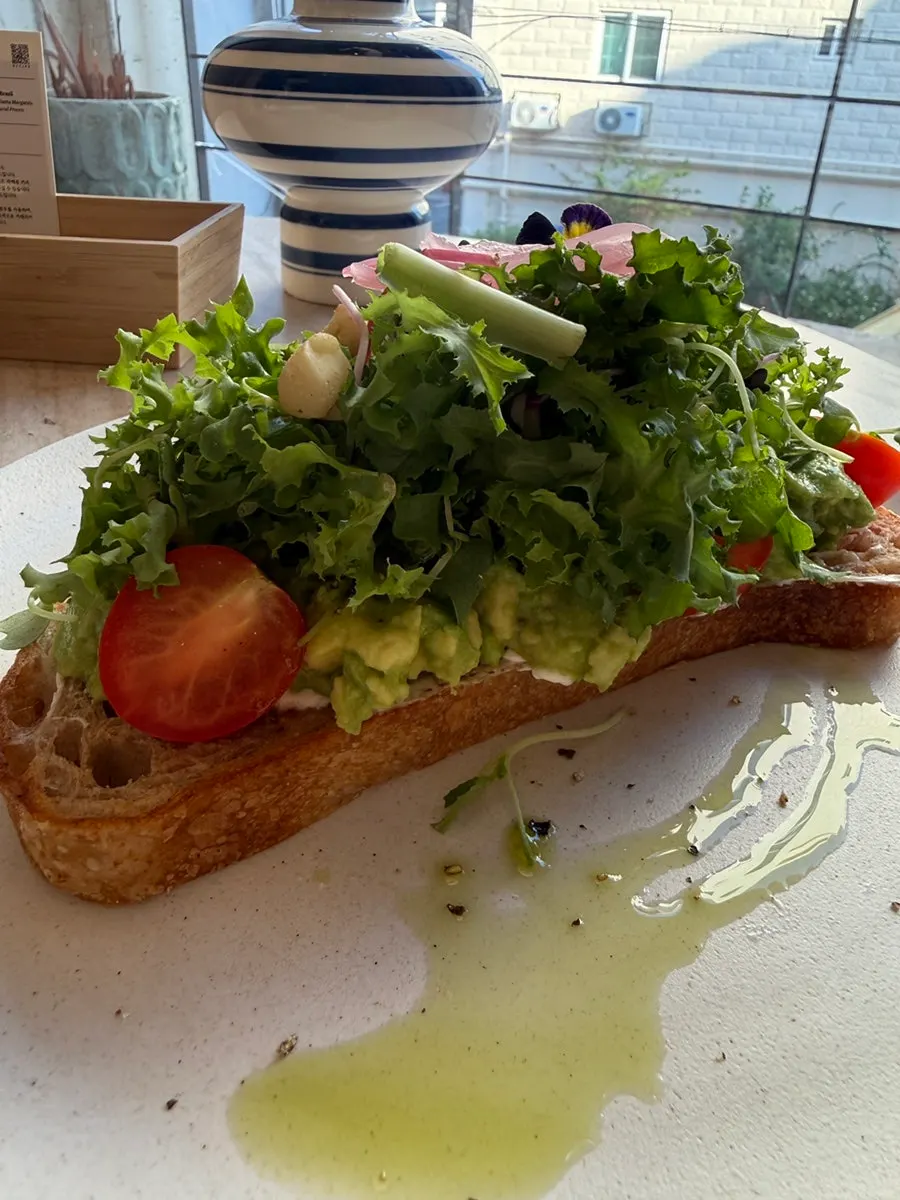 Open sandwich topped with vegetables and avocado