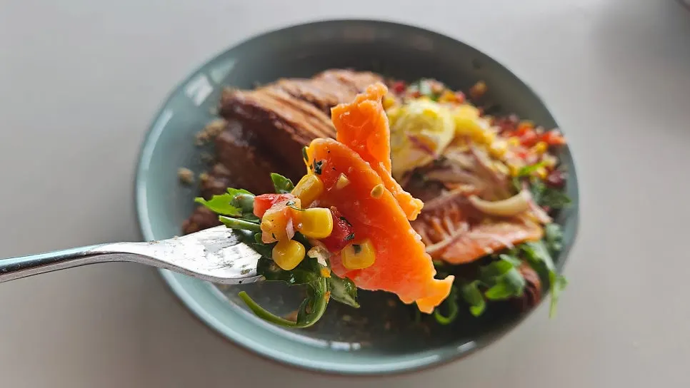 Close-up of salmon Benedict with arugula and tomato