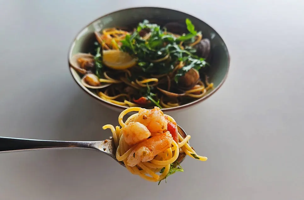 Close-up of oil pasta with clams and tomato