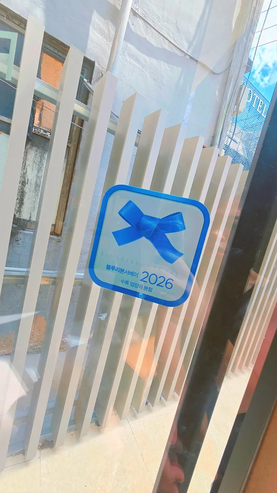 店内に貼られたブルーリボンサーベイ2026のステッカー