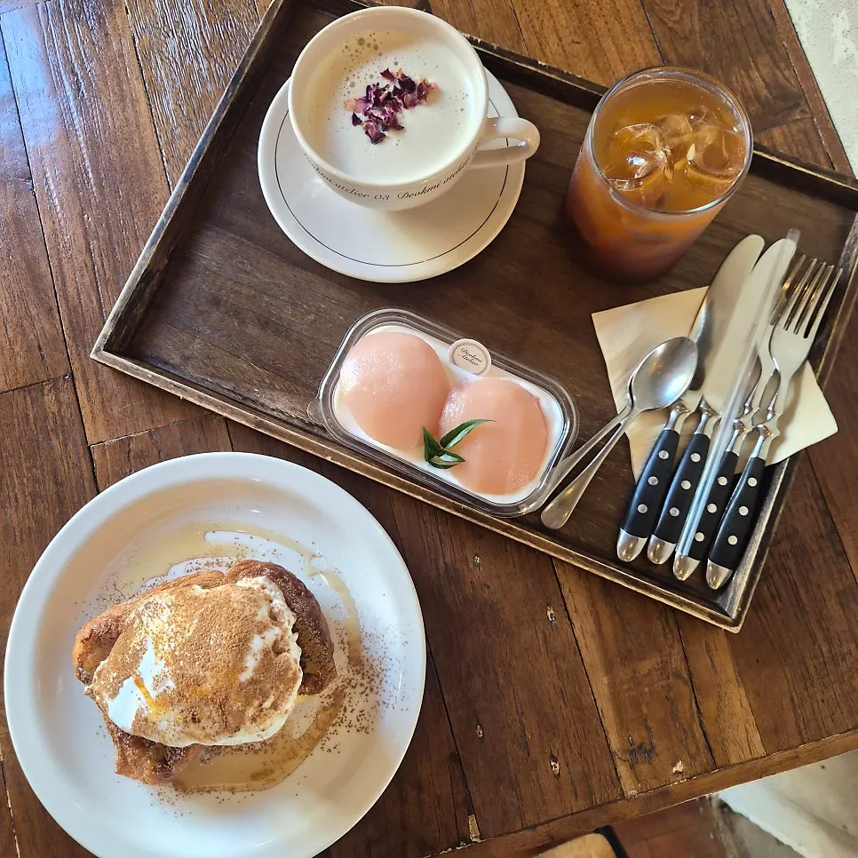 Table with toast, tiramisu, and drinks set out