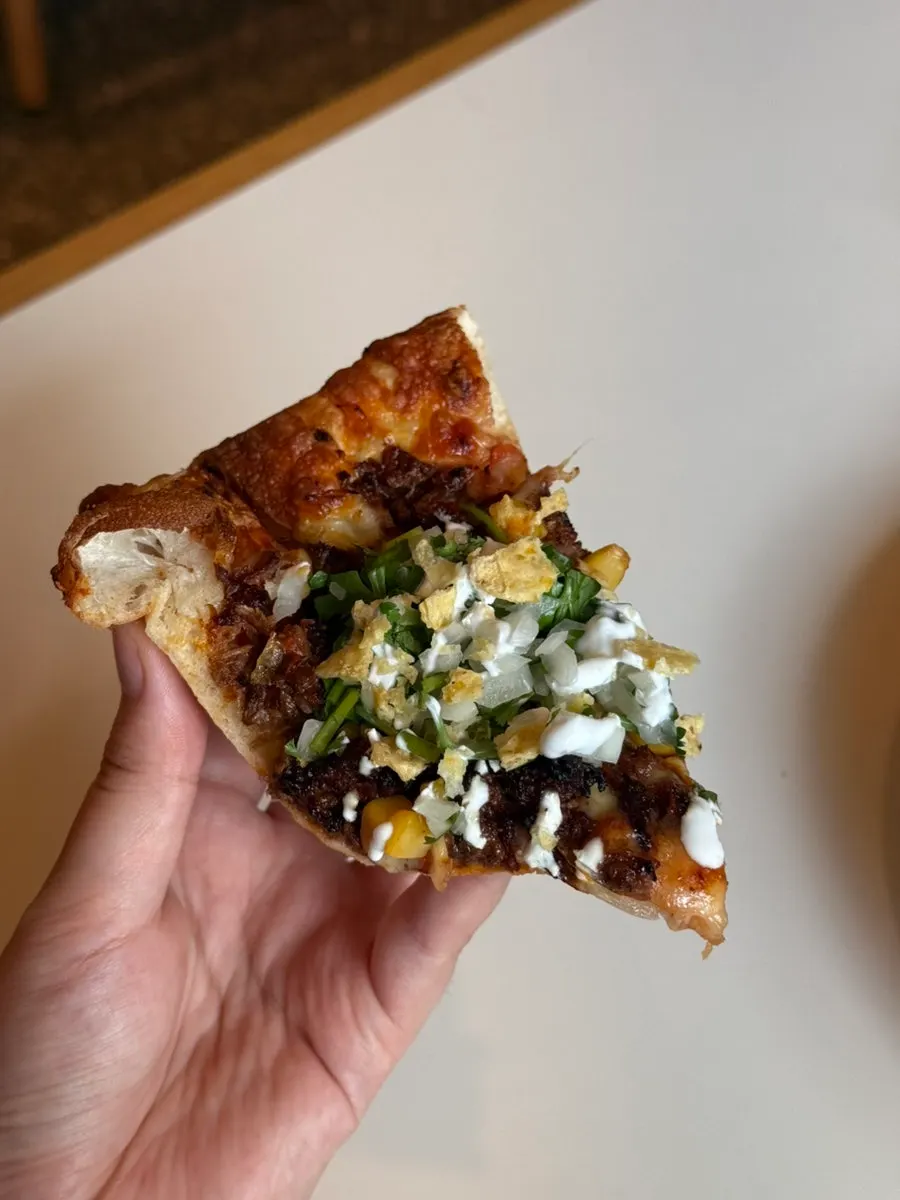 Close-up of a birria taco pizza slice