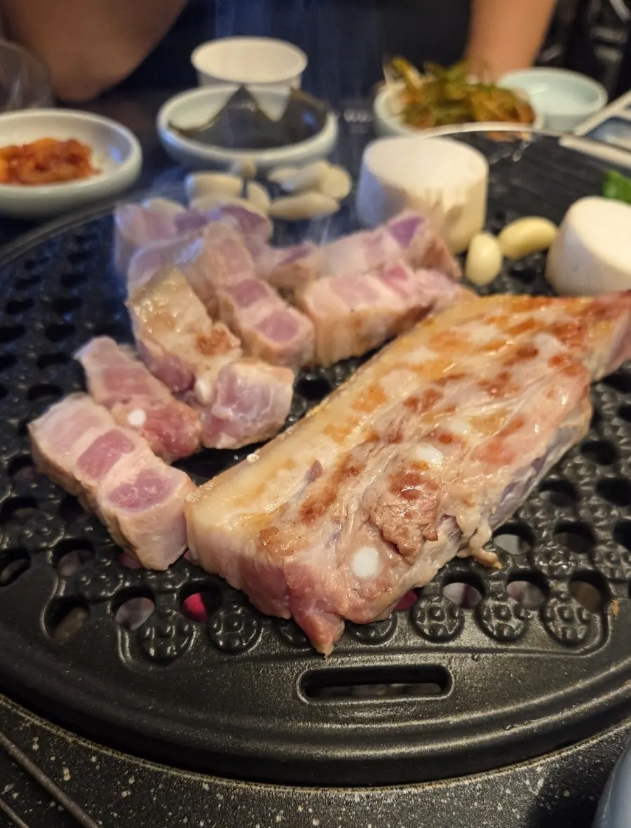 직원이 숯불에 고기를 구워주는 모습