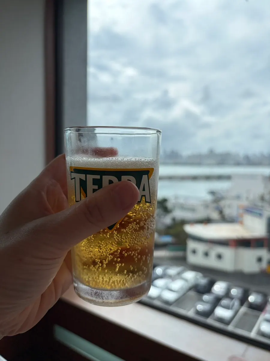 Sashimi and a glass of beer on a sea-view table
