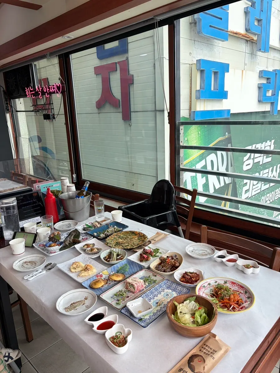 Sashimi, seafood, and side dishes continuing across the dachi spread