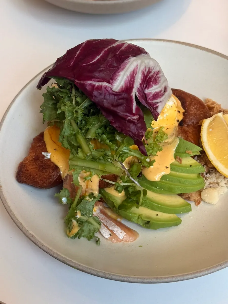 The Famous Benny with salmon, avocado, and soft-boiled egg on croissant